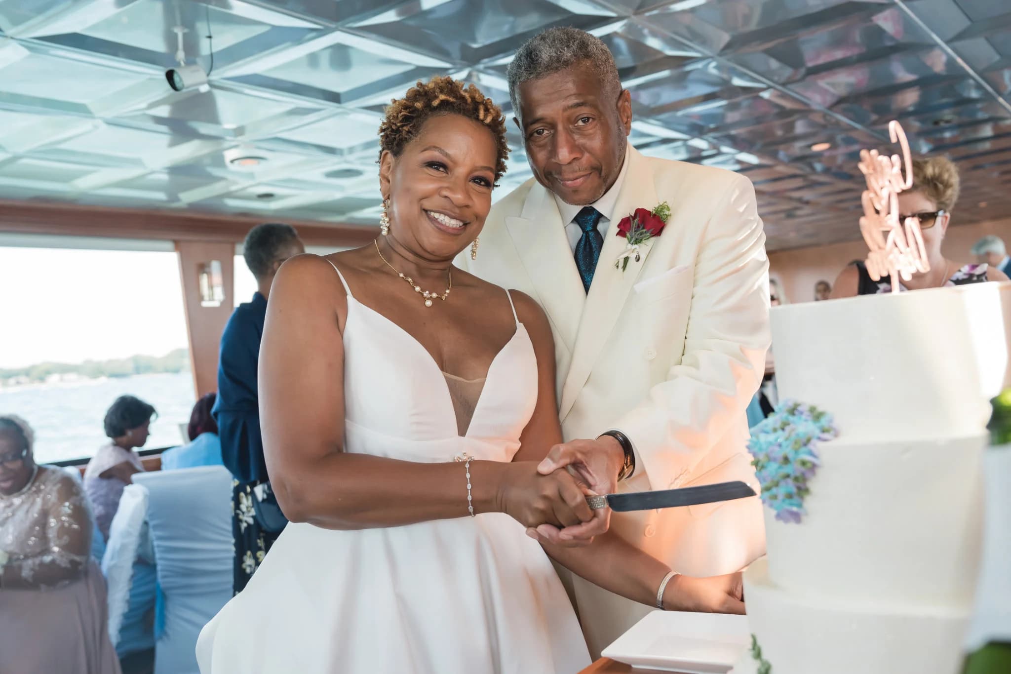 Joyful couple cutting wedding cake