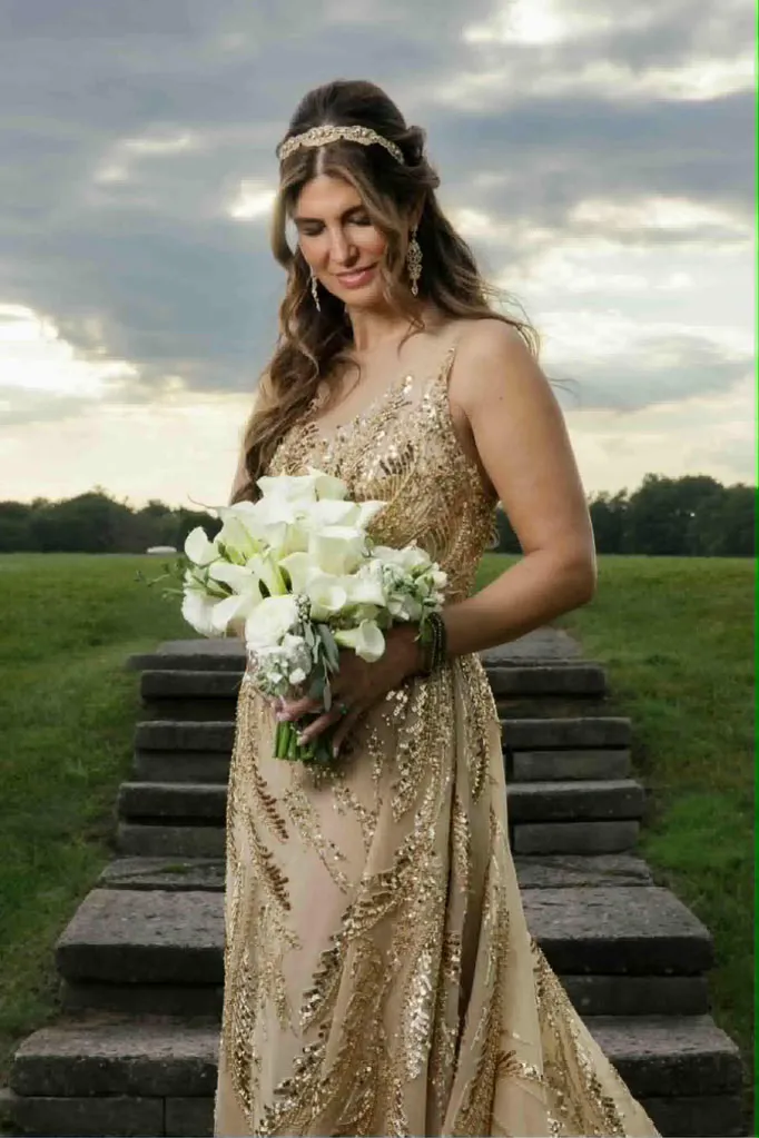 Bride in gold gown with headpiece and lily bouquet